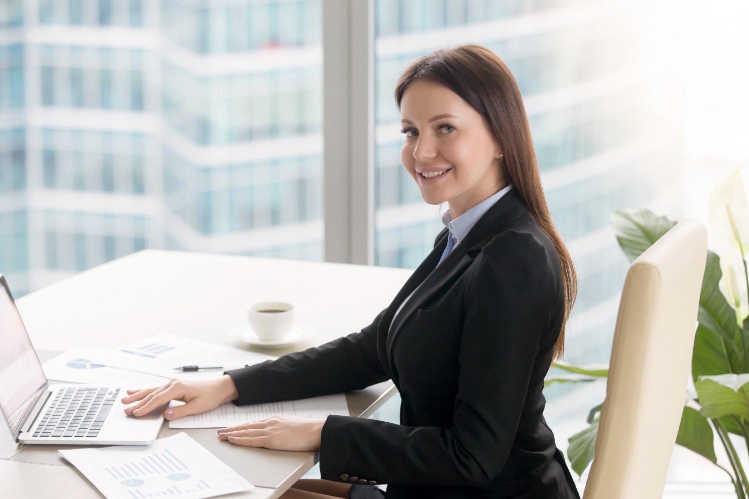 smiling-cheerful-young-businesswoman-working-office-desk-with-laptop